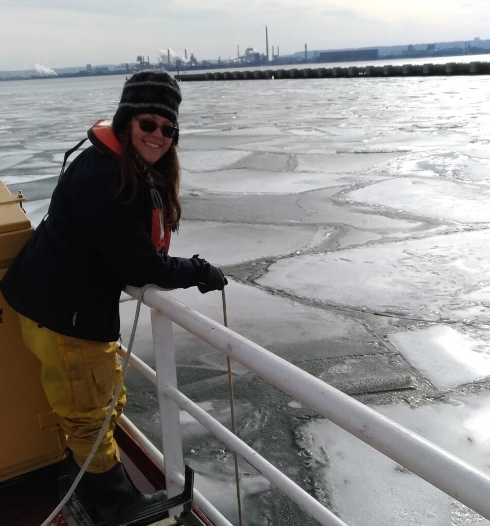 Biologist rope sampling from ship rail in ice floe covered waters.